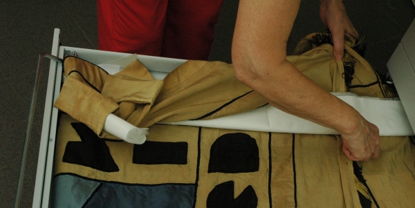Opvullen van de vouwen met synthetische watten in een jasje van zuurvrij papier. Foto: © Dienst Erfgoed Lanaken