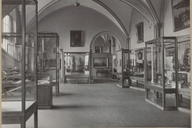 Modellenzaal met schilderijen en scheepsmodellen in vitrinekasten, 1900 - 1949. Rijksmuseum afdeling Beeld via Rijksstudio, publiek domein